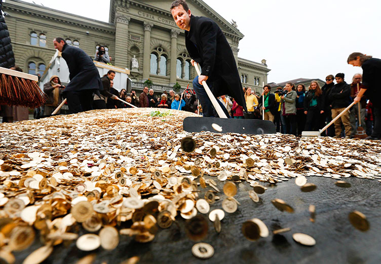 Швейцарці вчаться «загрібати гроші лопатою»: на акції на підтримку ініціативи перед парламентом у Берні розсипали 15 т монет. 
