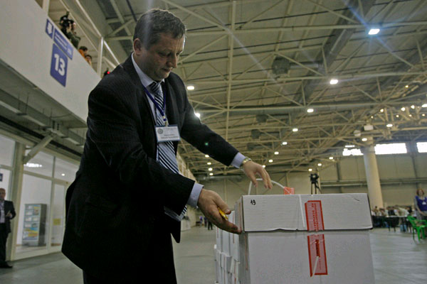 Секретар ВККС Анатолій Марцинкевич розпаковує зошити із тестовими завданнями для кандидатів у судді. Київ, 5 червня 2012 року